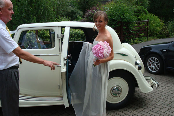 Bride traveling in style in Vintage Triumph wedding car